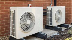 Two air source heat pumps installed on the exterior of a modern house