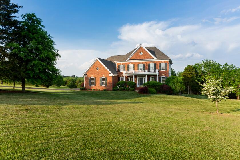 Detached house USA - Front of large single American family home with large garden lawn on a warm sunny summer day