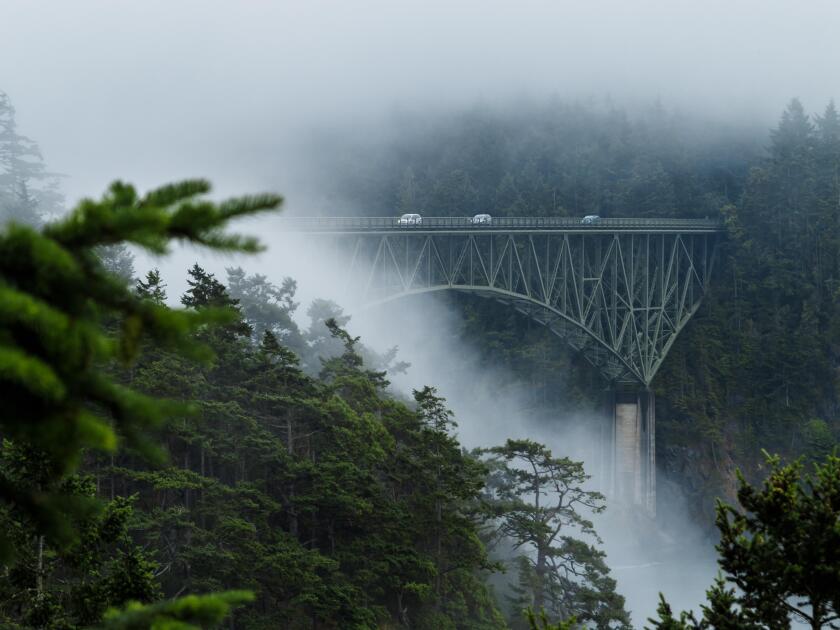 Cars on end of bridge still visible as mist settles over mountain gorge in Seattle