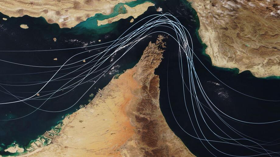 Satellite view of the Strait of Hormuz with white graphic lines representing global shipping lanes and maritime traffic between the Persian Gulf and G