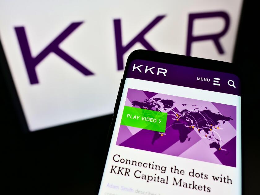Mobile phone with webpage of US investment company KKR and Co. Inc. on screen in front of business logo. Focus on top-left of phone display.