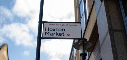 Street sign for Hoxton Market in the London Borough of Hackney under a clear sky.