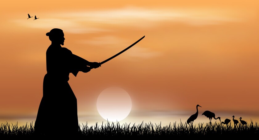 Samurai stands with a sword in his hands against the backdrop of a sunny sunset. Japanese landscape.