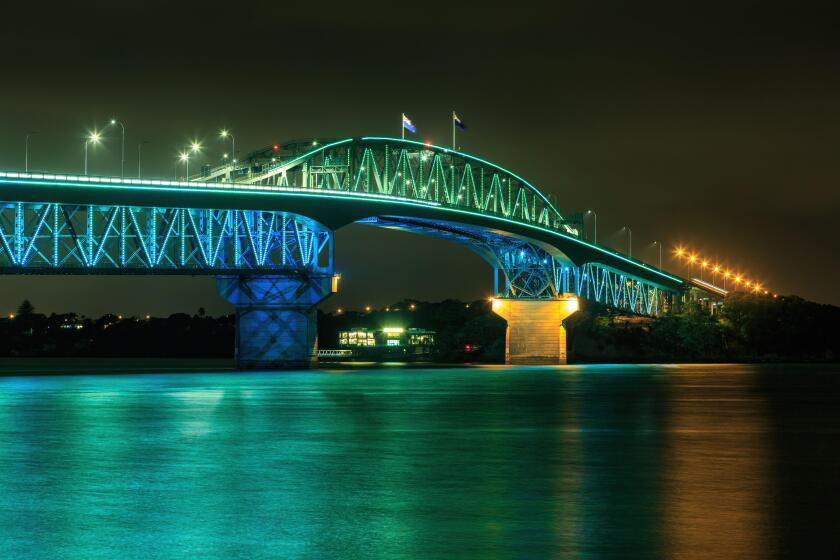 The Auckland Harbour Bridge, Auckland, New Zealand, colorfully lit at night during Auckland Anniversary