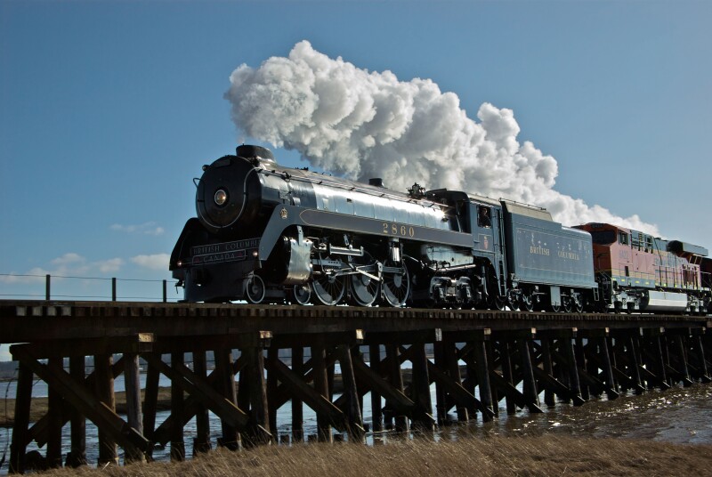 Restored CPR Royal Hudson 2860 steam engine crossing Serpentine River estuary railway train trestle