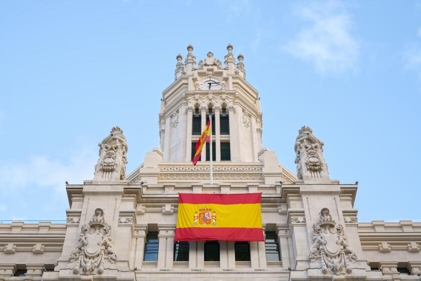 Cybele Palace in the historical center of Madrid, Spain. Madrid city hall with flag of Spain.