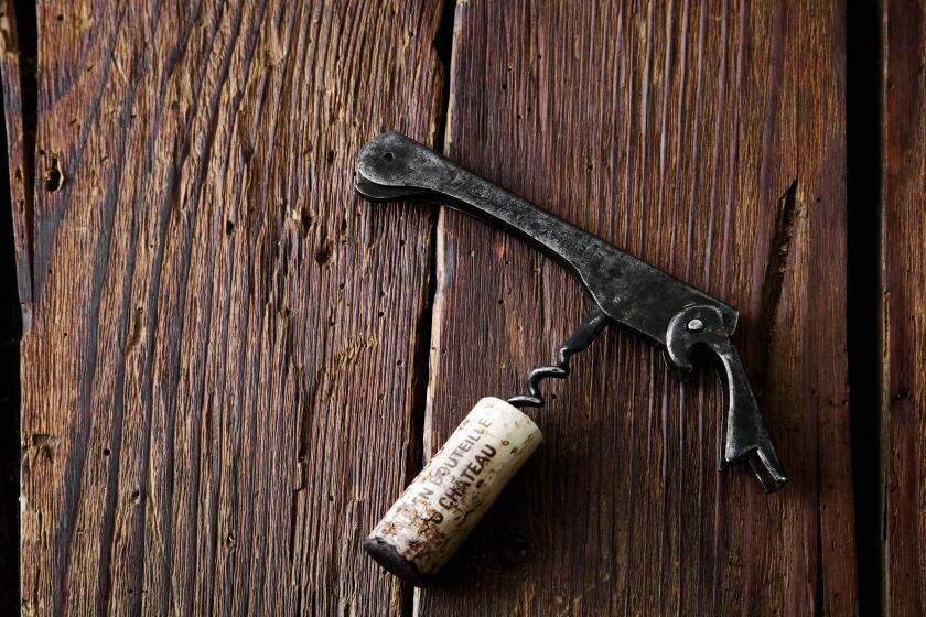 cork and corkscrew on a rustic wooden background