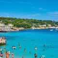 Scenic Seaside Beach Resort with Tourists Enjoying Swimming and Relaxing Under Umbrellas at La Garoupe beach, Cap d'Antibes, Cote d'Azur, France