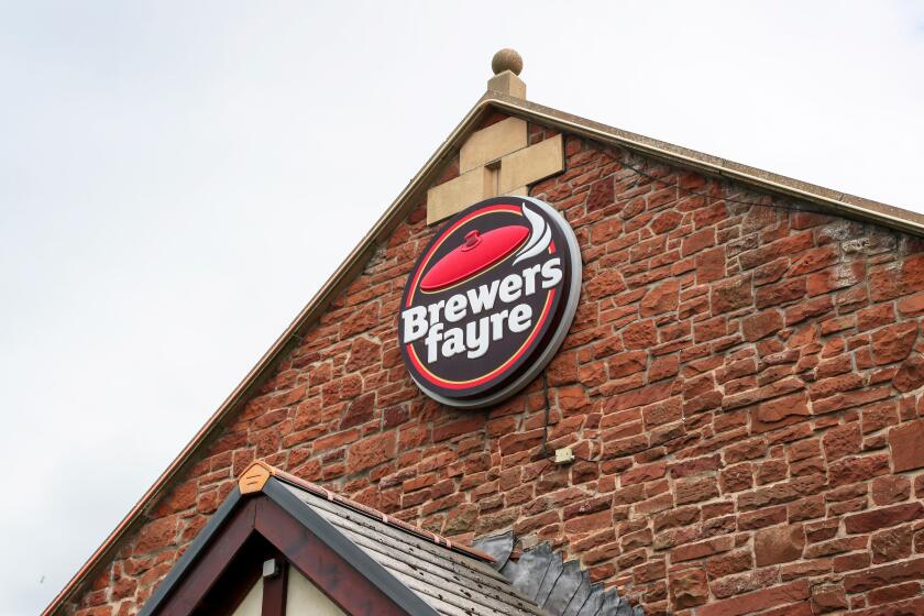 Logo sign for Brewers Fayre restaurant, above a food retail outlet, Prestwick, Scotland, UK