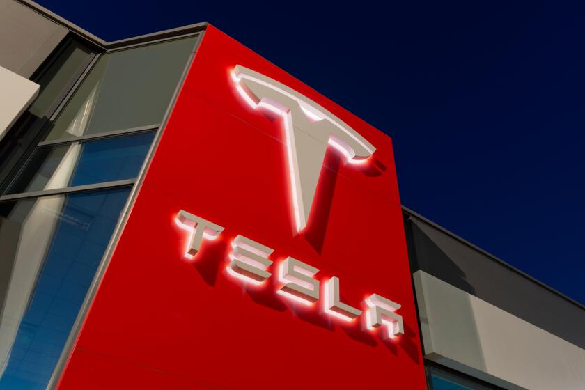Signage for the Tesla motor company at nigtht outside one of its showrooms in South Manchester, UK.