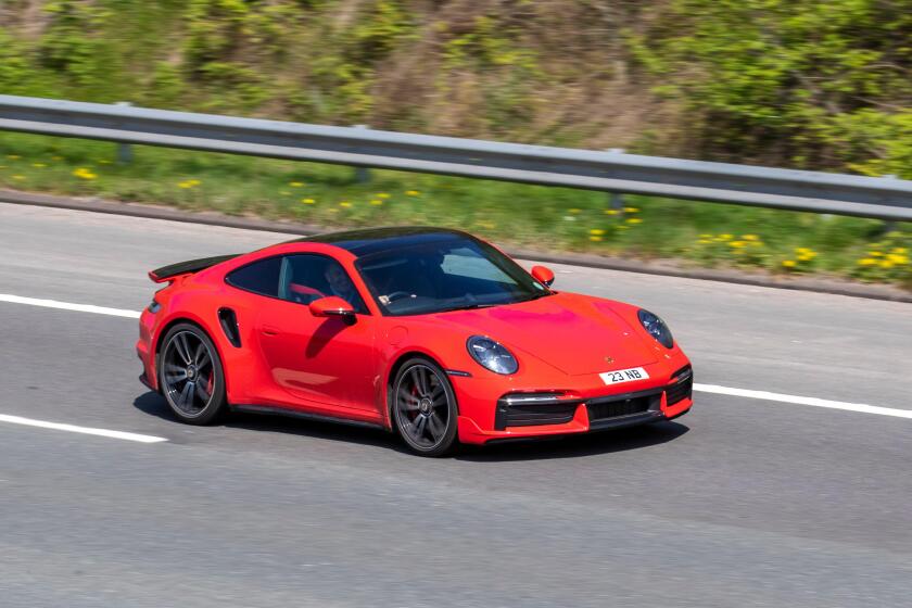 2021 red Porsche 911 TURBO S-A S PDK 3745cc petrol coupe; driving on the M61 motorway in Manchester, UK