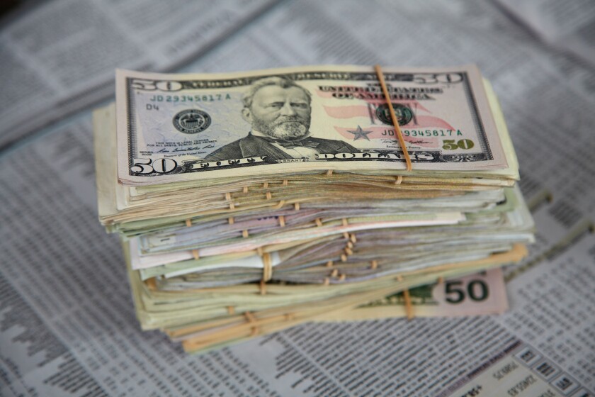 US dollars and financial pages in newspaper