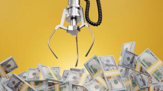 Robotic claw of grab machine is grasping stacks of one hundred US dollar bills. Earning profit, successful investment and business competition