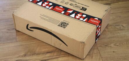 WARSAW, POLAND - DECEMBER 18, 2023: Amazon online store order box package delivered in Europe before Christmas, with holiday design tape.