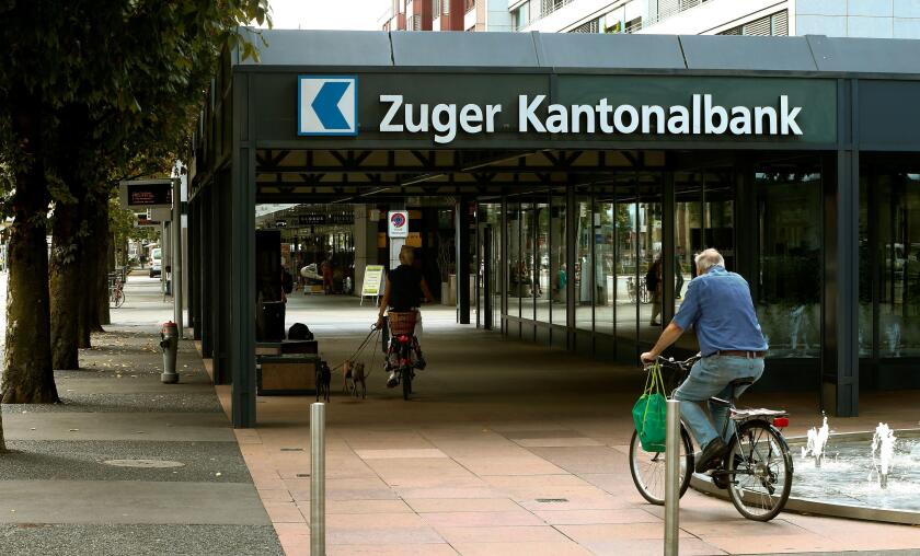 People cycle in front of the headquarters of Zuger Kantonalbank bank in Zug, Switzerland August 30, 2016.  REUTERS/Arnd Wiegmann