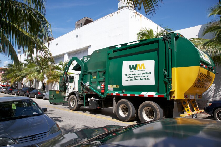 refuse truck collecting rubbish bins in miami south beach florida usa