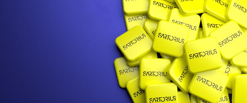 Logos of the pharmaceutical and laboratory equipment supplier Sartorius (member of DAX 40 as of Sept 2021) on a heap on a table. Copy space. Web banne