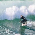 A male surfer riding a wave on a surfboard near Huntington Beach