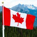 Canadian Maple Leaf national Flag flying over mountains