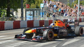 Former F1 driver David Coulthard driving the Red Bull Racing RB7 Formula 1 car during the Red Bull Showrun in Budapest, with crowds and photographers