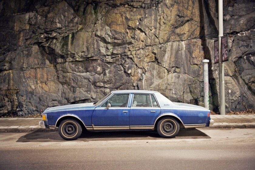 A blue car against a stone wall, Sweden.