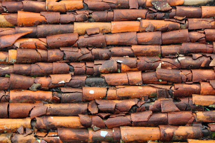 Rustic and broken clay roof tiles on a house