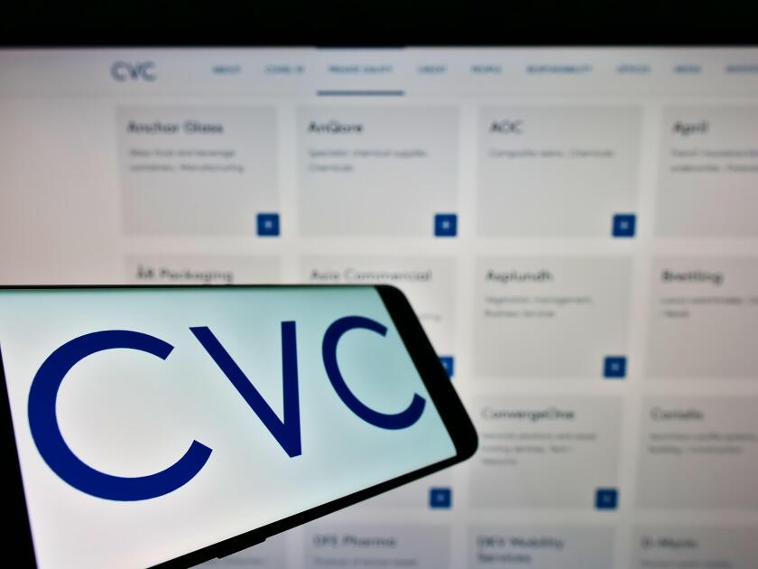 Smartphone with logo of private equity company CVC Capital Partners on screen in front of business website. Focus on center-left of phone display.