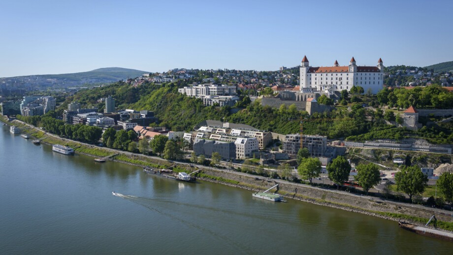 Bratislava Castle and the Old Town skyline over the Danube River, with bridge traffic and city landmarks on a clear day