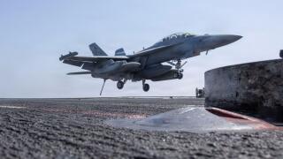 The USS Abraham Lincoln (CVN 72) is a Nimitz-class aircraft carrier in the U.S. Navy. The archival photograph captures an EA-18G Growler, attached to Electronic Attack Squadron (VAQ) 133, making an arrested landing on the flight deck on 28 February 2026 i