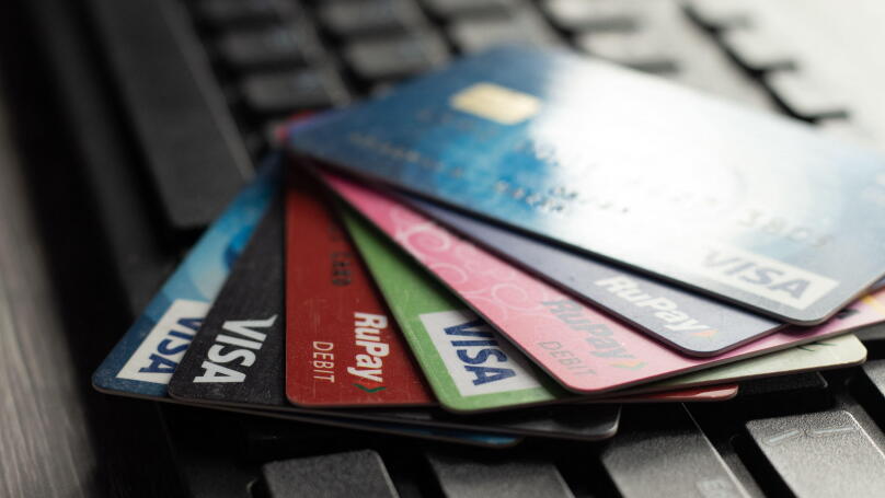 Selective focus on a group of credit and debit cards placed on a computer keyboard