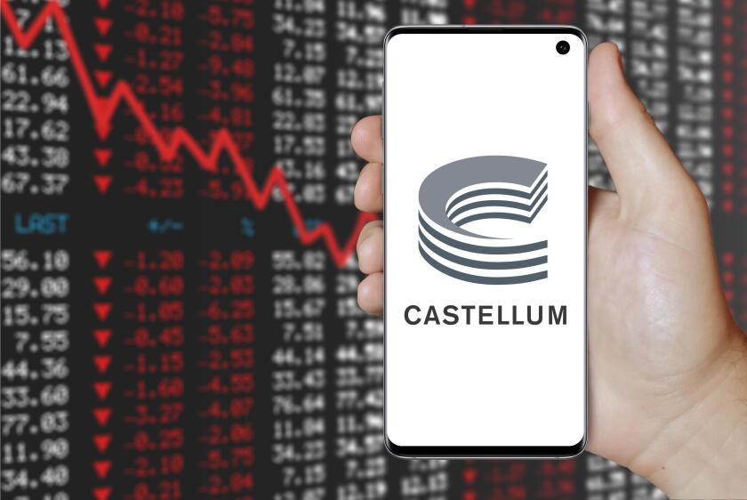 A man holds a smartphone displaying the logo of company Castellum listed on OMX Stockholm. Negative stock market background. Credit: PIXDUCE