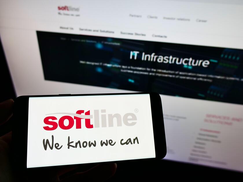 Person holding mobile phone with logo of global IT solutions provider Softline International on screen in front of web page. Focus on phone display.