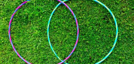 Two overlapping hula-hoops on grass. A Colorful, stylized VENN figure. Two intersecting circles. Contours. Stylish. Minimalist
