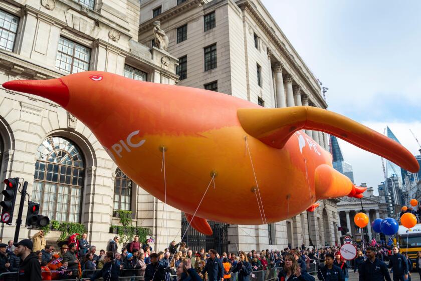 Pension Insurance Corporation float at the Lord Mayor's Show parade in the City of London, UK. Large inflatable penguin floating through City streets