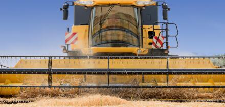 close front view of modern combine harvester in action.