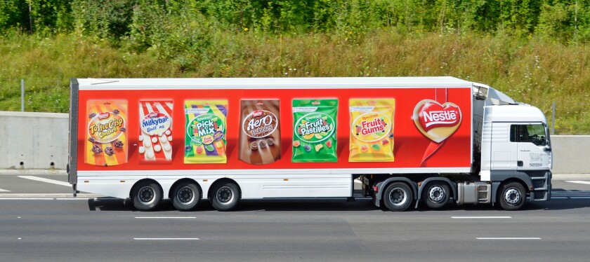Nestle hgv supply chain delivery lorry truck & articulated trailer colourful advertising display of its  products driving along M25 Motorway Essex UK