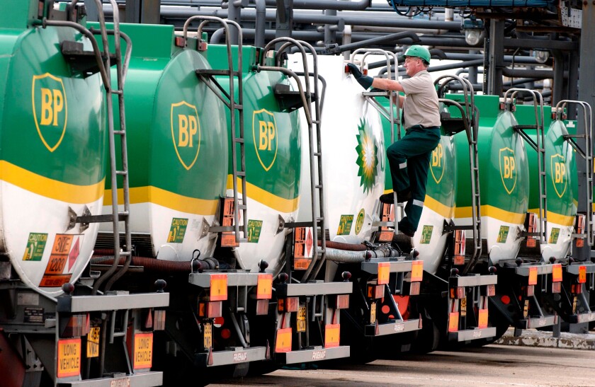 BP tankers lined up for inspecton with BP employee checking them over.. Image shot 2002. Exact date unknown.