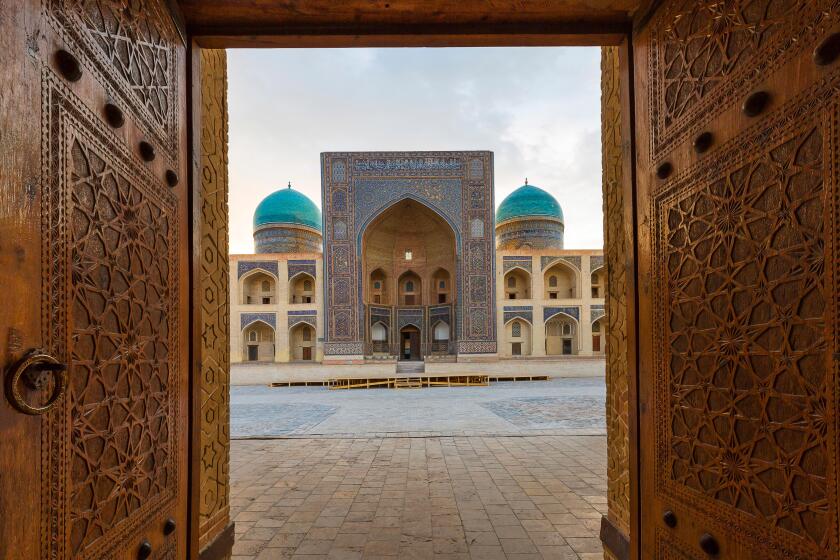 Poi Kalon Madrassa through the carved wooden doors in Bukhara, Uzbekistan.
