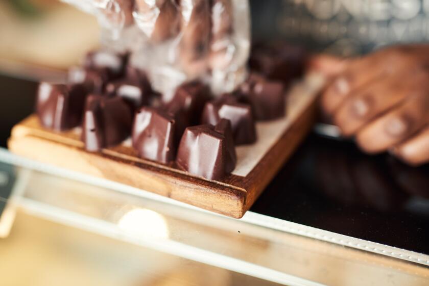 Chocolatier arranging pieces of chocolate on a display case