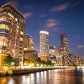 A skyline view of office and condominium towers along The Canary Wharf pier and neighbourhood at dusk.  The Thames River, London UK.