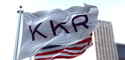 New York, USA, November 2021: The flag With KKR logo waving in the wind with the American national flag blurred in the background