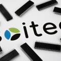 SOITEC company logo on the paper document and large microchips placed around. Illustrative for electronic chip manufacturer.  Selective focus. Staffor