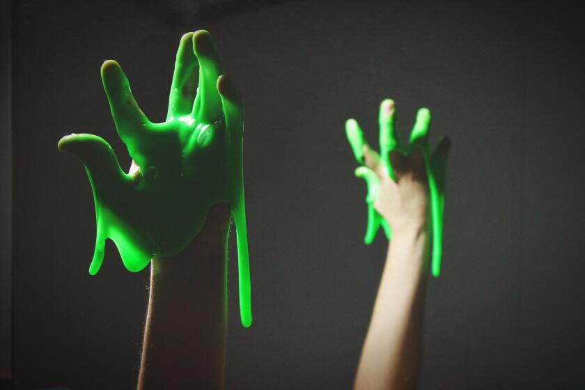 Cropped Hand With Green Slime Against Black Background