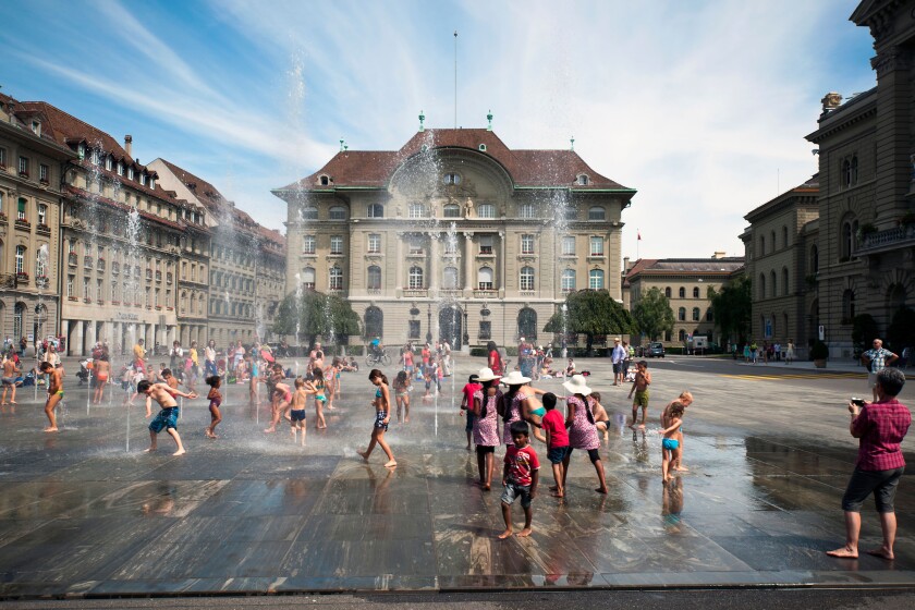 Children playing in the fountains in front of Swiss National Bank in Bern.