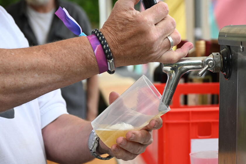 Beer is poured from a tap into a reusable plastic cup at a casual outdoor festival event, concept for sustainable open-air entertainment, fun and cold