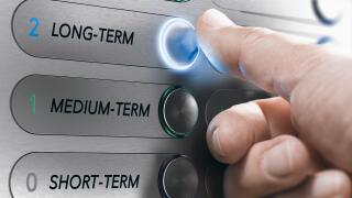 Man pushing an elevator buttons where it is written long term. Investment Concept. Composite image between a hand photography and a 3D background.