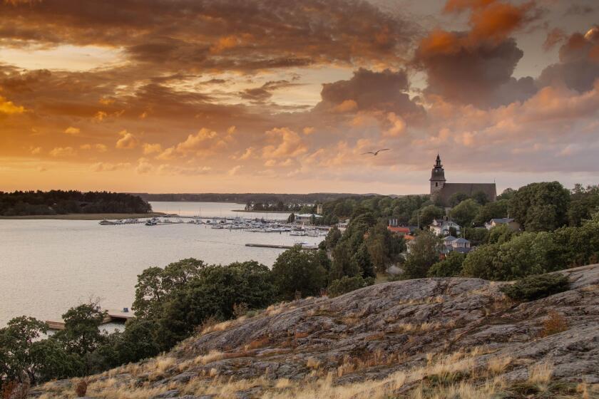 A dramatic colorful sunset in Naantali, Finland with the church and archipelago, sea and Moomin island