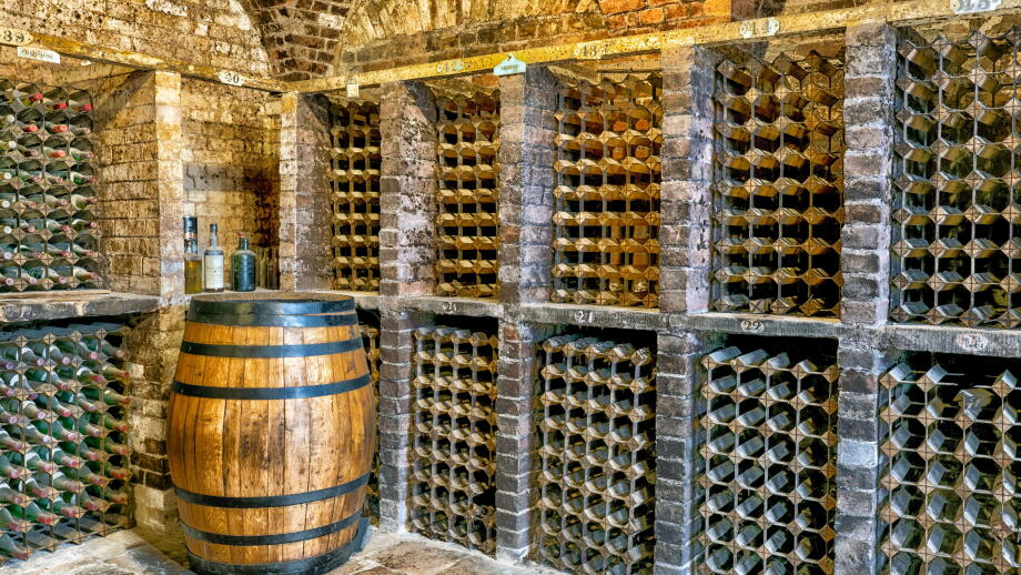 Traditional wine cellar featuring brick vaulted ceilings and stone flooring at Kingston Lacy country house, Kingston Lacy, Dorset, England, UK