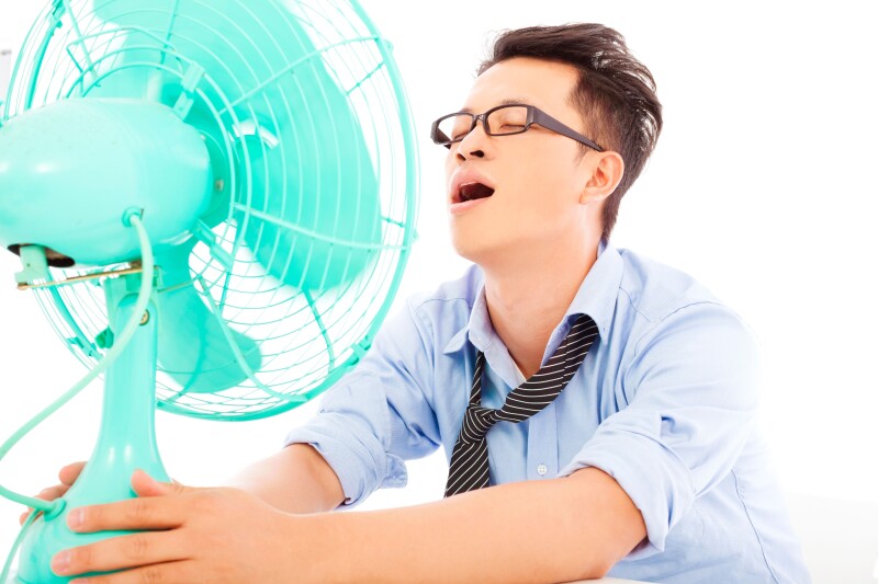 business man suffering a hot summer heat with fans