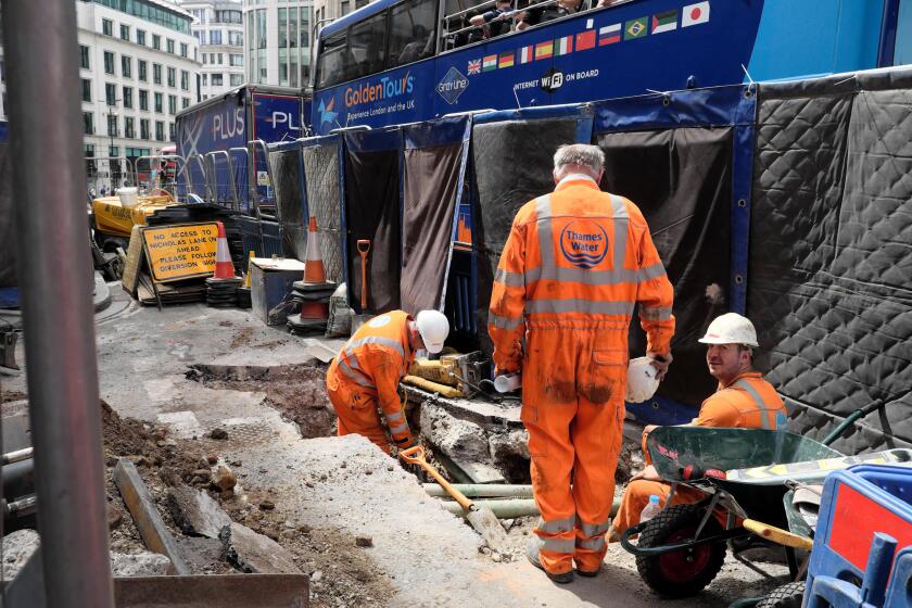 Thames Water worker and workmen work digging up road with buses on King William Street in the summer of 2019 City of London England UK  KATHY DEWITT